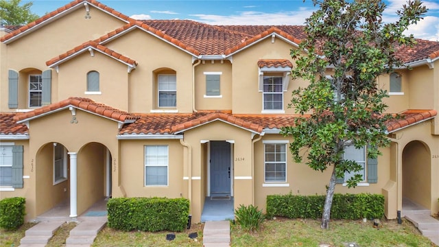 mediterranean / spanish-style house featuring a tiled roof and stucco siding