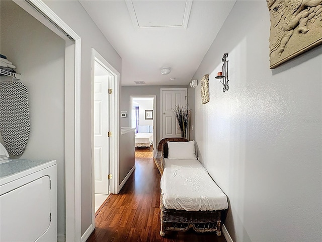 hallway with visible vents, separate washer and dryer, dark wood-style flooring, and baseboards