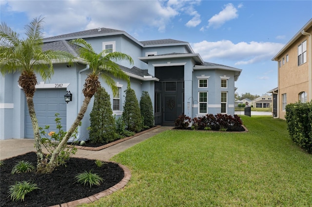 view of front of property with a front yard, a garage, and stucco siding