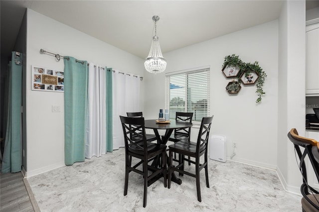 dining space with a chandelier and baseboards