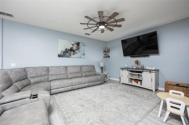 living area with ceiling fan, visible vents, baseboards, and wood finished floors