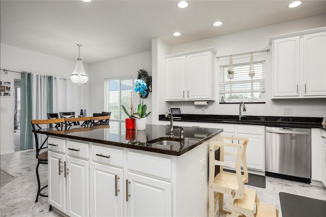 kitchen featuring a sink, dark stone countertops, stainless steel dishwasher, white cabinets, and a kitchen island with sink