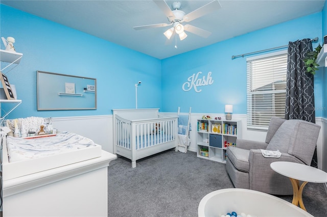 bedroom featuring carpet flooring, a ceiling fan, and a nursery area