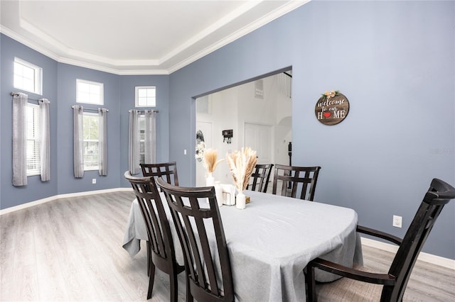 dining area with light wood finished floors, arched walkways, and baseboards