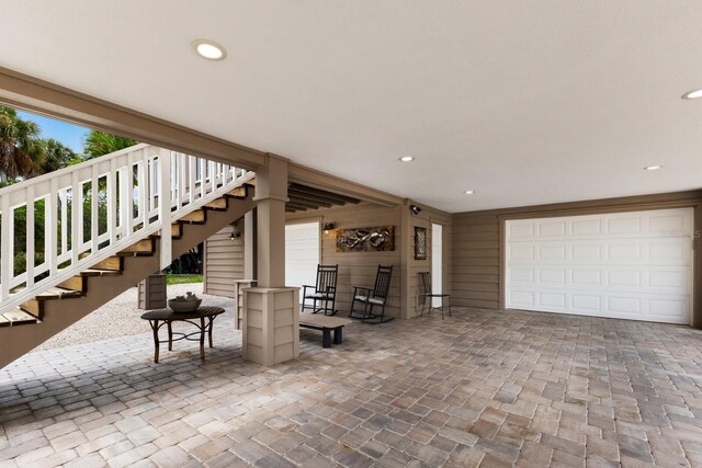 view of patio / terrace with stairs, decorative driveway, and a garage