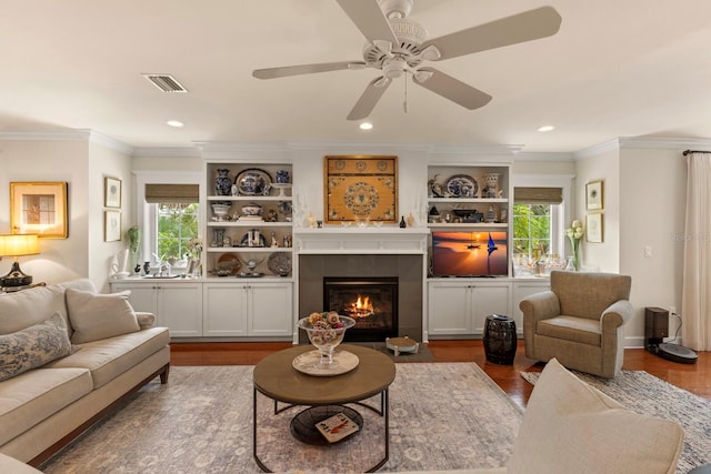 living area featuring visible vents, plenty of natural light, and wood finished floors