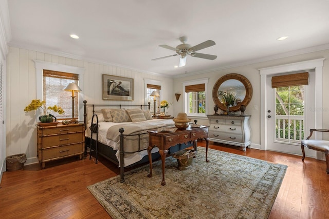 bedroom with multiple windows, wood finished floors, crown molding, and access to exterior