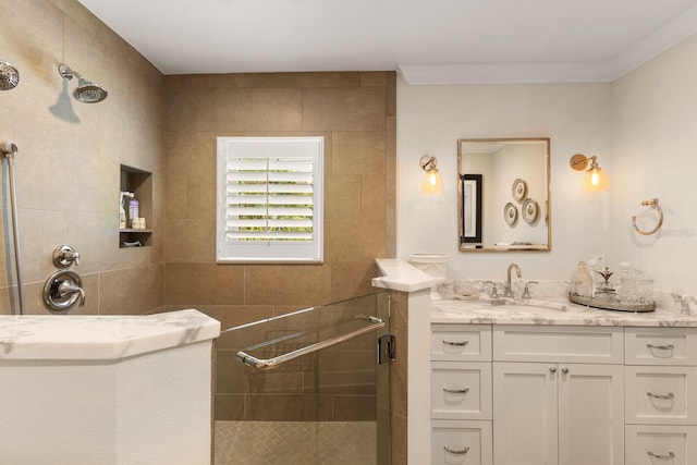 full bathroom featuring vanity, crown molding, and tiled shower