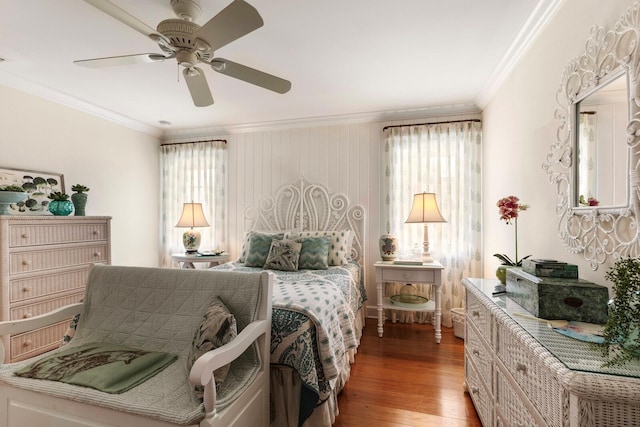 bedroom with a ceiling fan, multiple windows, light wood-style floors, and crown molding