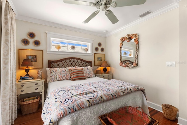 bedroom with baseboards, wood finished floors, visible vents, and ornamental molding