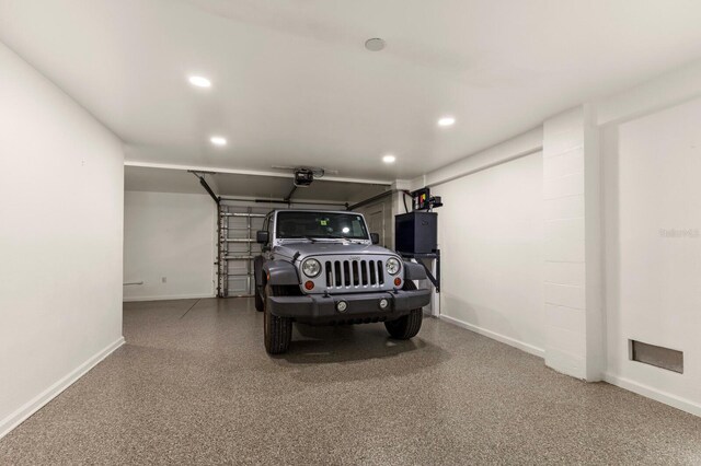 garage with recessed lighting, a garage door opener, and baseboards