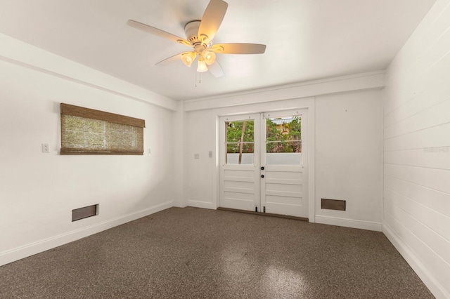 carpeted spare room with french doors, baseboards, and ceiling fan