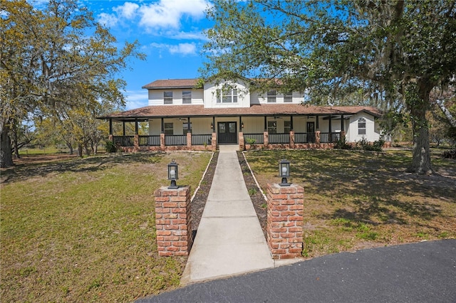 farmhouse featuring a front lawn and covered porch