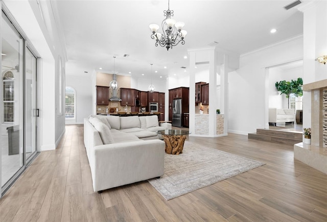 living room featuring baseboards, light wood-style flooring, recessed lighting, ornamental molding, and a notable chandelier