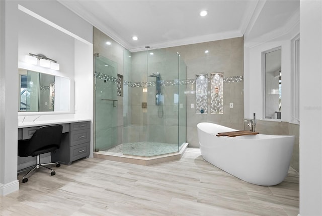 bathroom with tile walls, a shower stall, crown molding, a freestanding bath, and vanity