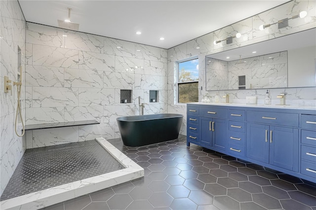 full bath featuring a walk in shower, tile walls, tile patterned flooring, double vanity, and a soaking tub