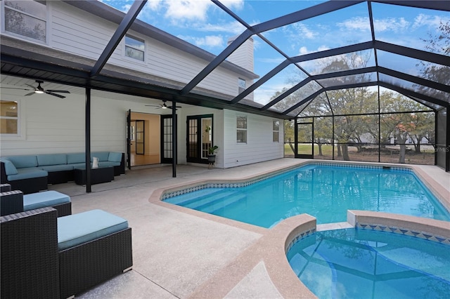 view of swimming pool with a pool with connected hot tub, glass enclosure, an outdoor hangout area, ceiling fan, and a patio area