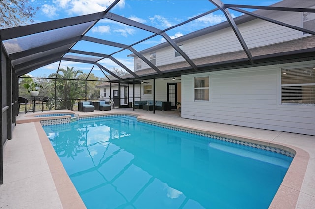 view of swimming pool with a patio area, a lanai, outdoor lounge area, and a ceiling fan