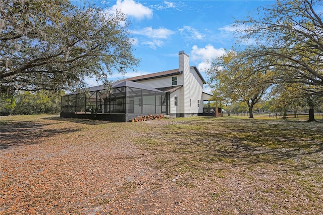 rear view of house with a lanai and a chimney