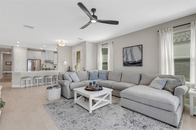 living area with recessed lighting, a ceiling fan, visible vents, and light wood finished floors