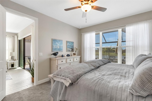 bedroom featuring light carpet, ceiling fan, and baseboards