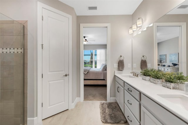 full bath featuring a tile shower, visible vents, connected bathroom, and a sink