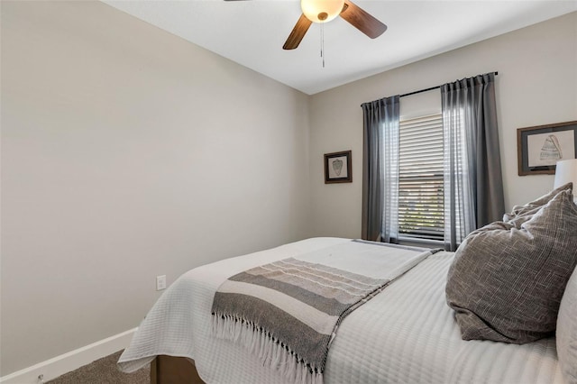 bedroom with a ceiling fan, baseboards, and carpet floors