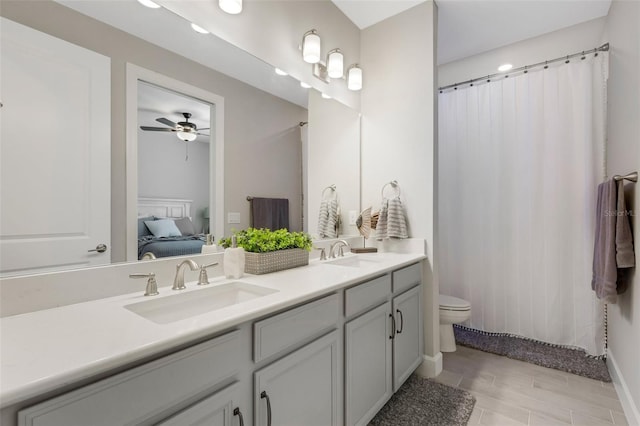 ensuite bathroom featuring double vanity, toilet, ensuite bathroom, and a sink