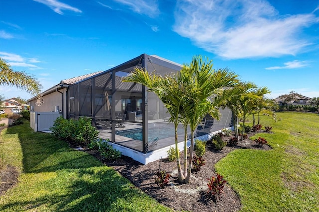 view of property exterior featuring stucco siding, a lawn, glass enclosure, an outdoor pool, and a patio area