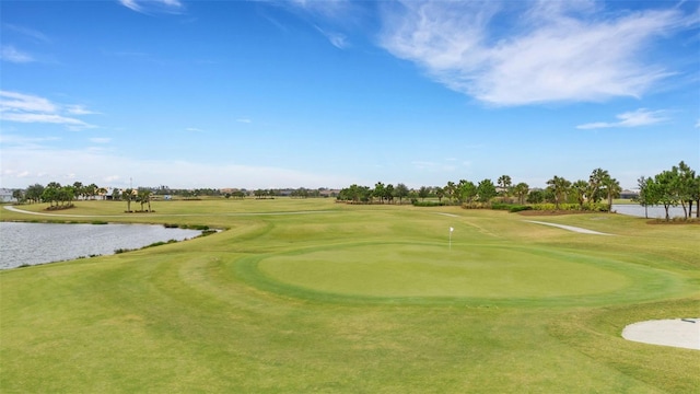 view of property's community featuring a yard, a water view, and view of golf course