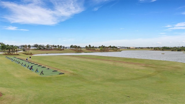 surrounding community with golf course view, a lawn, and a water view