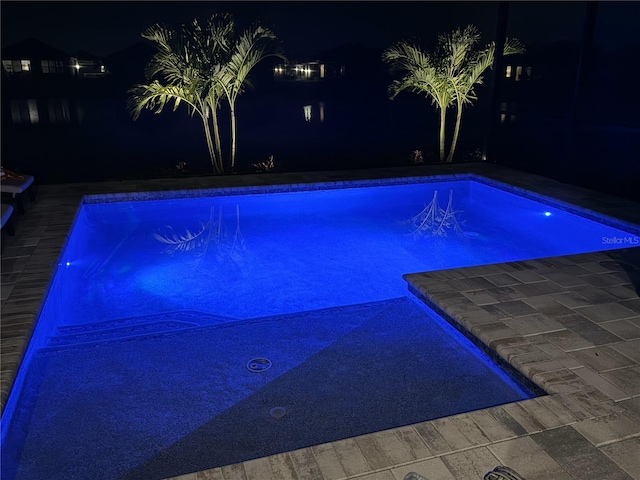 pool at twilight featuring an outdoor pool