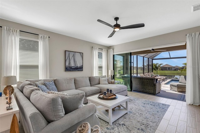 living area with visible vents, a sunroom, and ceiling fan