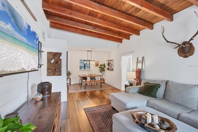 living room featuring beam ceiling, wooden ceiling, and wood finished floors