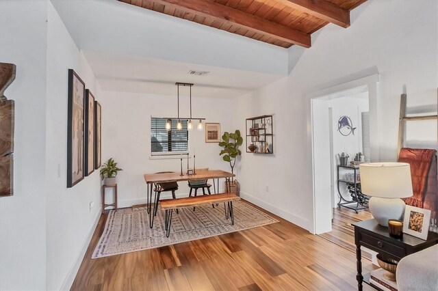 dining area featuring visible vents, baseboards, beamed ceiling, wood ceiling, and light wood-style flooring