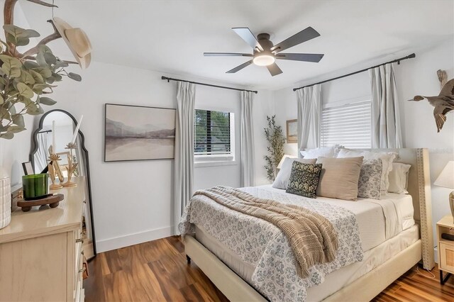 bedroom with ceiling fan, baseboards, and wood finished floors