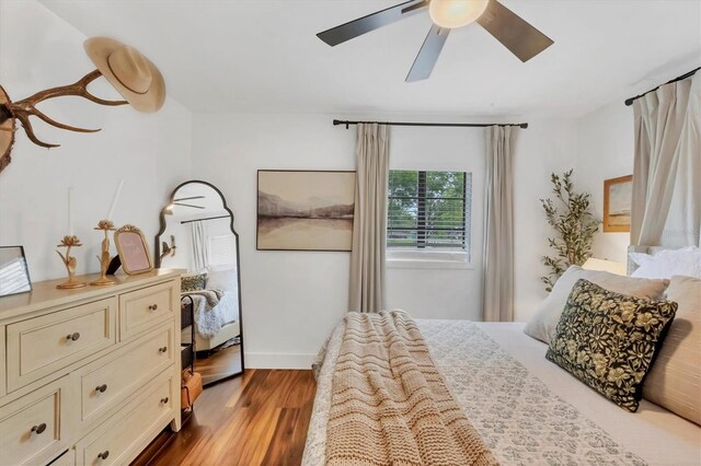 bedroom with baseboards, wood finished floors, and a ceiling fan