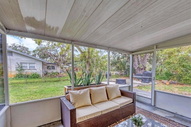 sunroom featuring vaulted ceiling, wood ceiling, and a healthy amount of sunlight