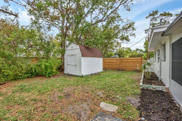 view of yard featuring a storage unit, a fenced backyard, and an outdoor structure