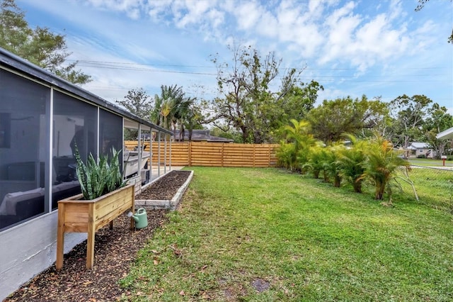 view of yard featuring a fenced backyard and a sunroom