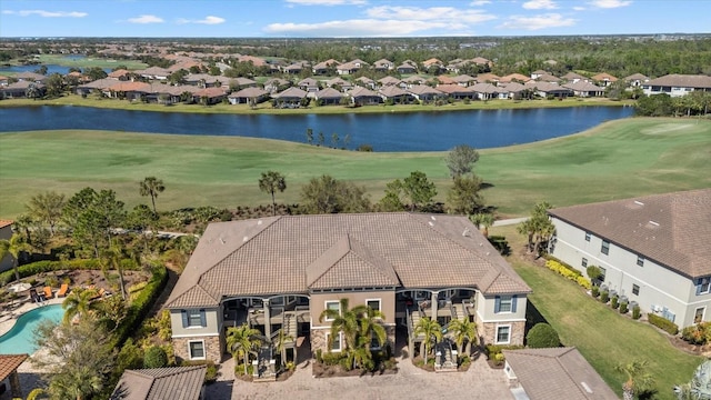 drone / aerial view featuring a residential view, golf course view, and a water view