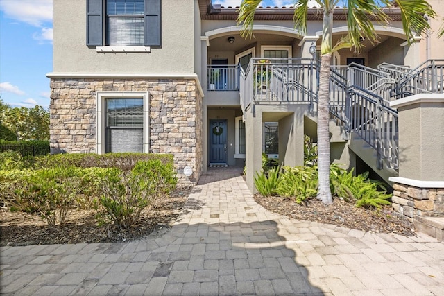 property entrance with stucco siding and stone siding