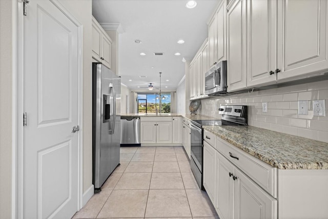 kitchen featuring light tile patterned floors, light stone countertops, recessed lighting, appliances with stainless steel finishes, and tasteful backsplash