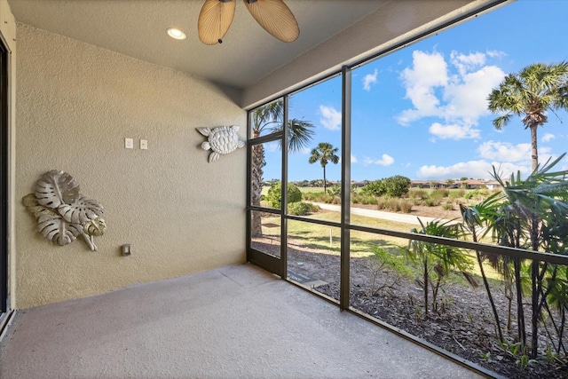 unfurnished sunroom with a ceiling fan