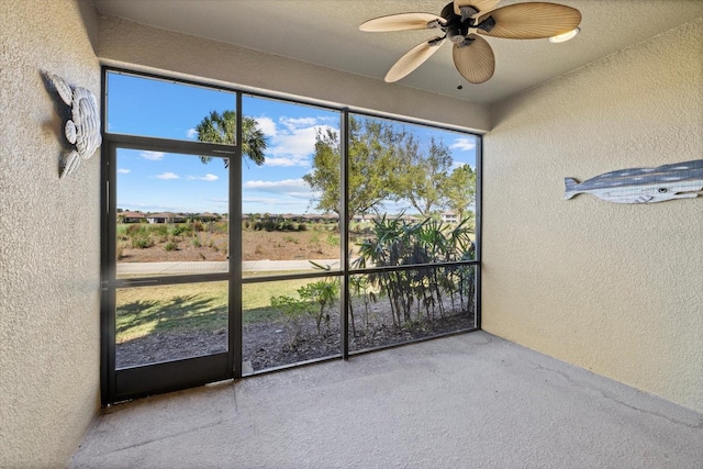 unfurnished sunroom with a wealth of natural light and a ceiling fan