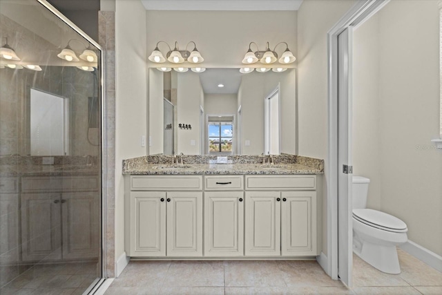 bathroom with double vanity, a shower stall, toilet, and a sink