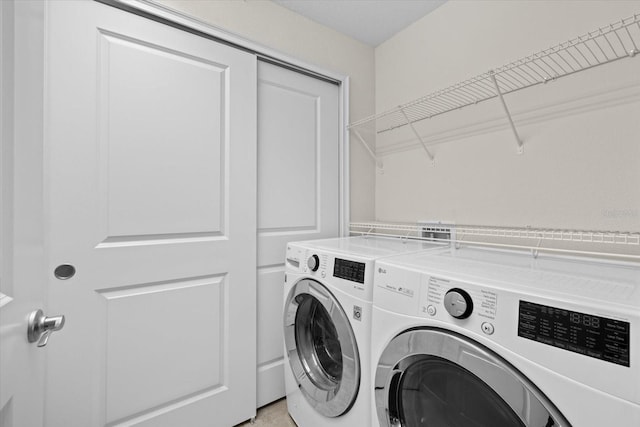 laundry room with laundry area and washing machine and clothes dryer