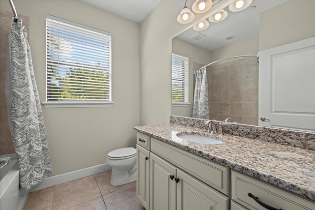 bathroom featuring tile patterned flooring, toilet, plenty of natural light, and baseboards