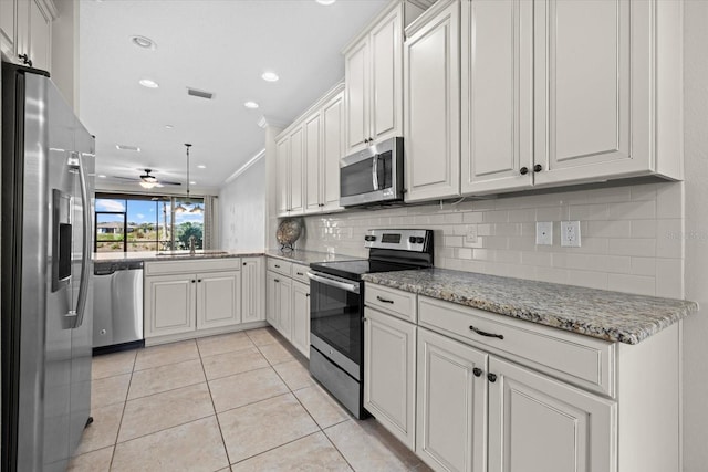 kitchen featuring visible vents, light tile patterned flooring, a sink, decorative backsplash, and stainless steel appliances