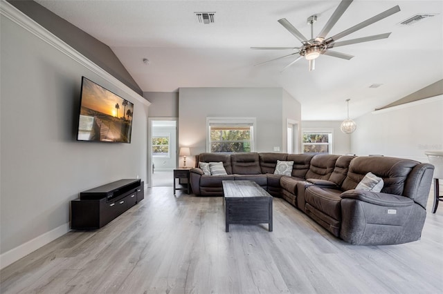 living area featuring visible vents, light wood-style flooring, and lofted ceiling